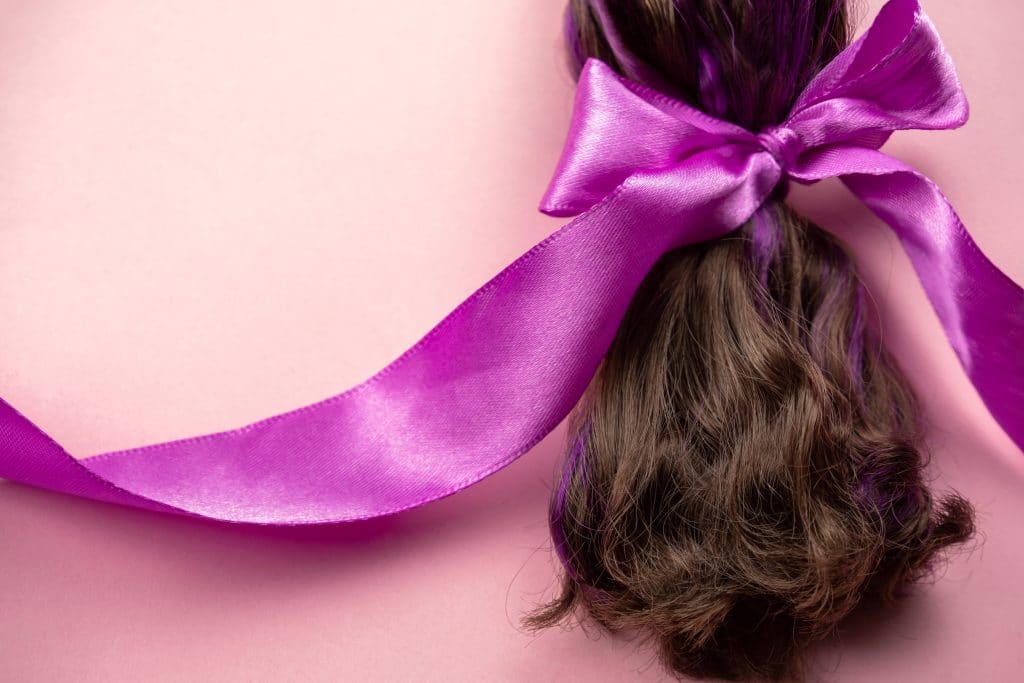 brown-hair-with-purple-strands-tied-in-a-ponytail-with-pink-satin-ribbon