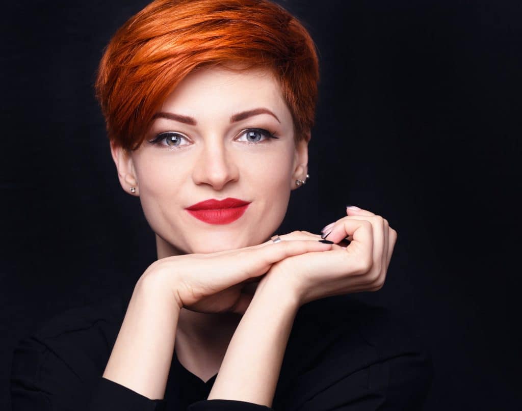 Portrait of a beautiful young red-haired woman with short hair o